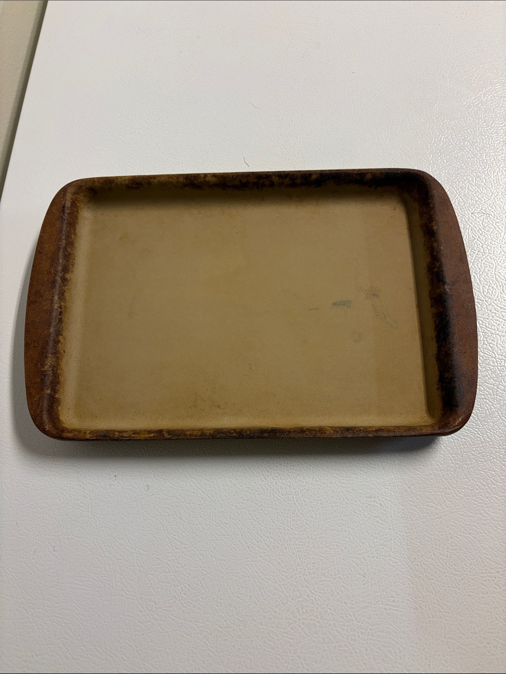 The Pampered Chef Rectangular Ceramic Baking Pan measures about 8 1/2“ x 11 1/2“